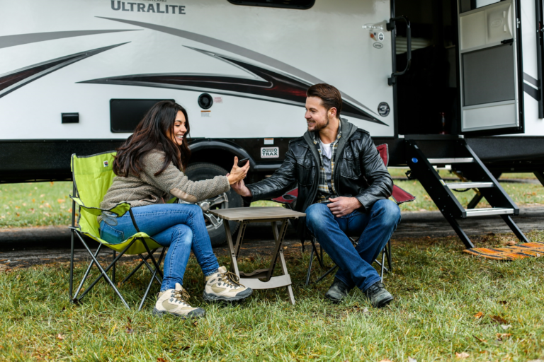 couple sitting camper trailer